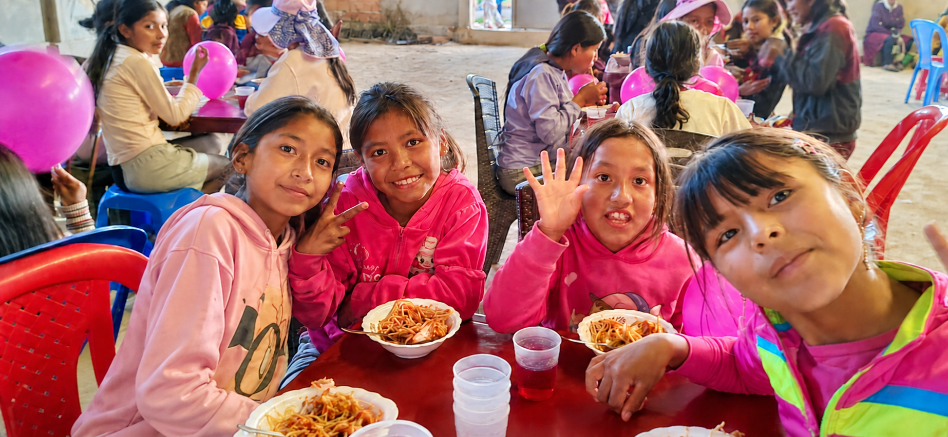 Children sharing a meal at a community gathering in Cochabamba, Bolivia